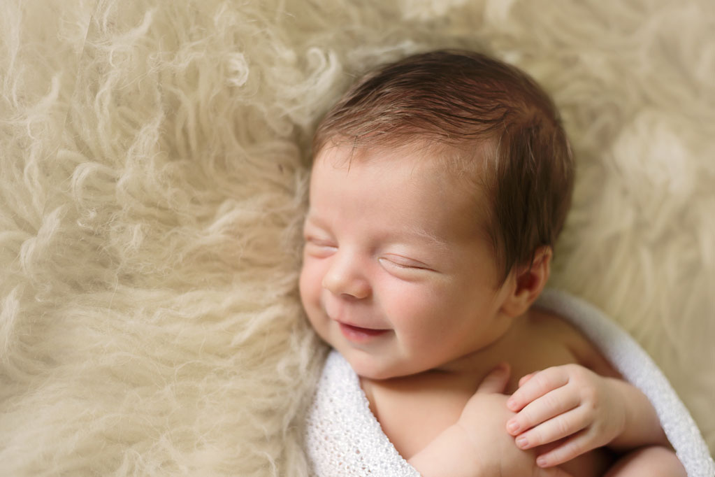 Baby Cooper smiling during newborn pictures in San Diego