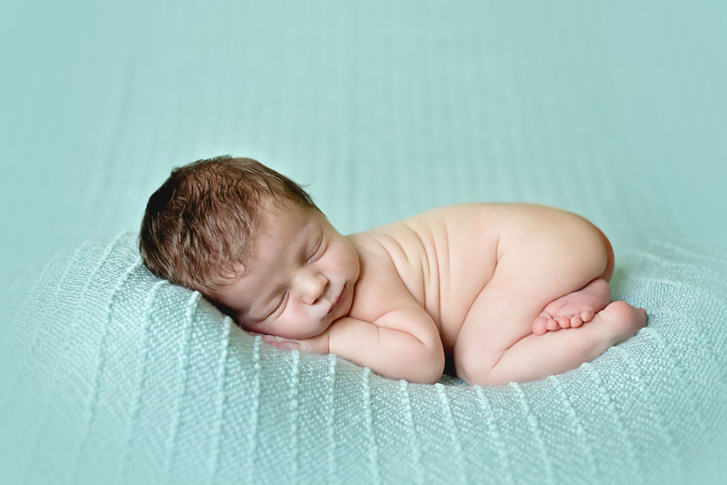 Baby Cooper posing curled up during baby pictures in San Diego CA