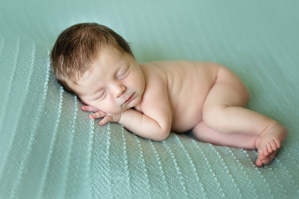 Baby Cooper sleeping all curled up during baby pictures in San Diego CA