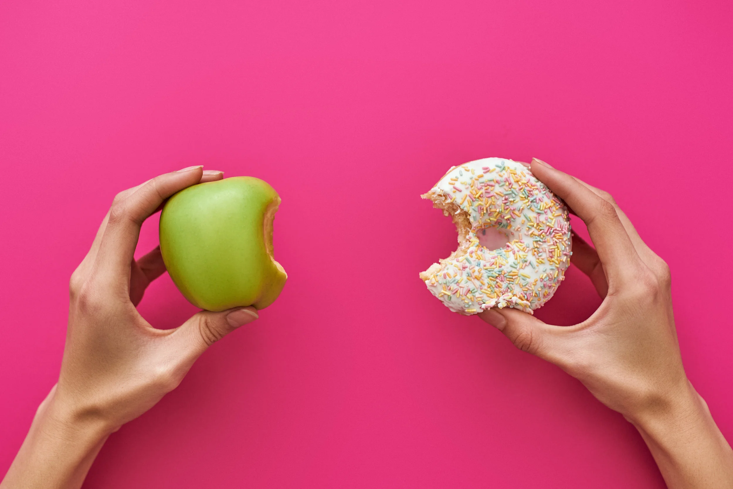 Dieting-or-good-health-concept.-Young-woman-trying-to-choose-between-apple-and-donut-1084344284_5904x3941.jpeg