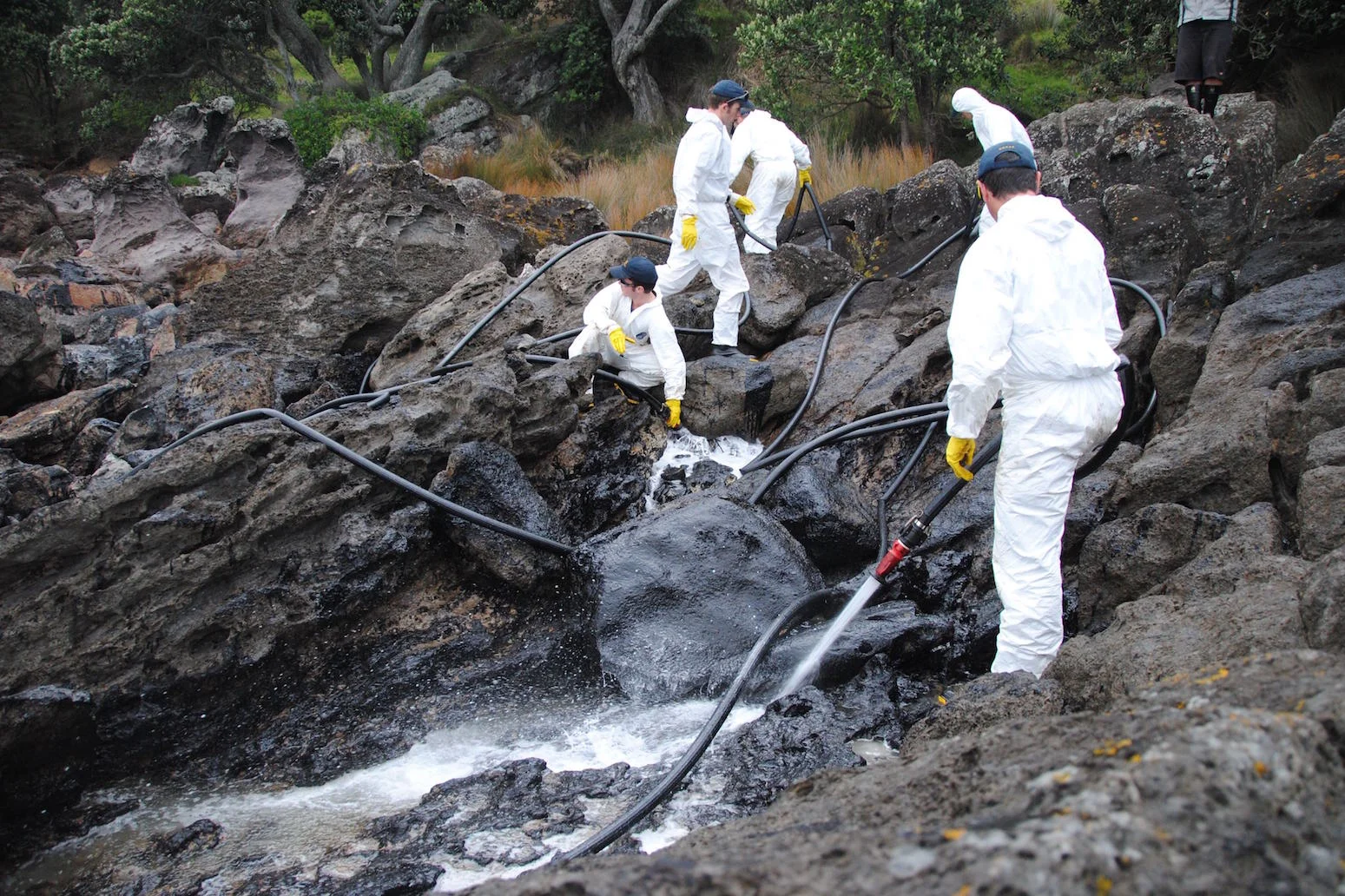 Flushing oiled rocks at Mount Maunganui following the Rena oil spill, 2011.
