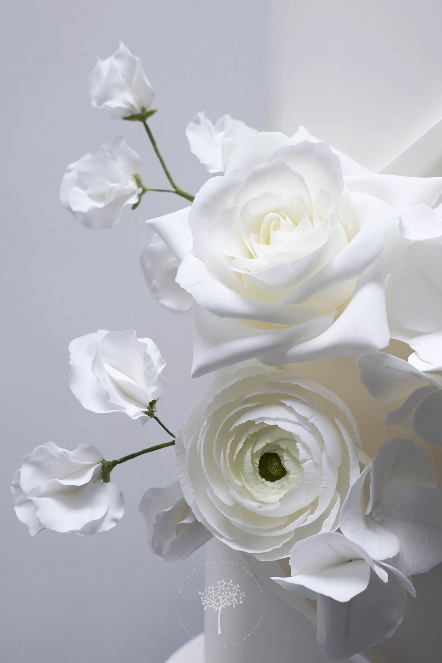 Close‑up of handcrafted white sugar flowers — including roses, ranunculus, sweet peas, and hydrangea — created by Blossom Tree Cake Company in Harrogate for luxury Yorkshire weddings at Grantley Hall.