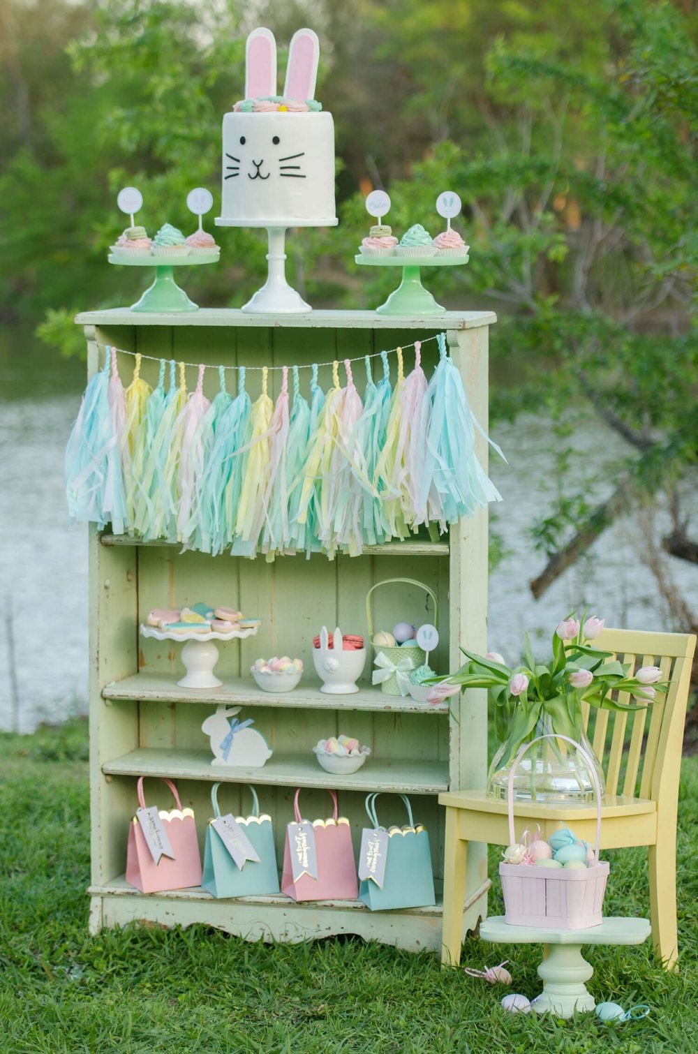 Be creative with your dessert table presentation. Here a mint colored shelf that matched the Easter party colors was used to display the party sweets, the cutest bunny cake and party favors. See more Easter Garden Party Ideas for Kids on Mint Event Design www.minteventdesign.com #easterparty #gardenparty #partysupplies #desserttable #eastertable