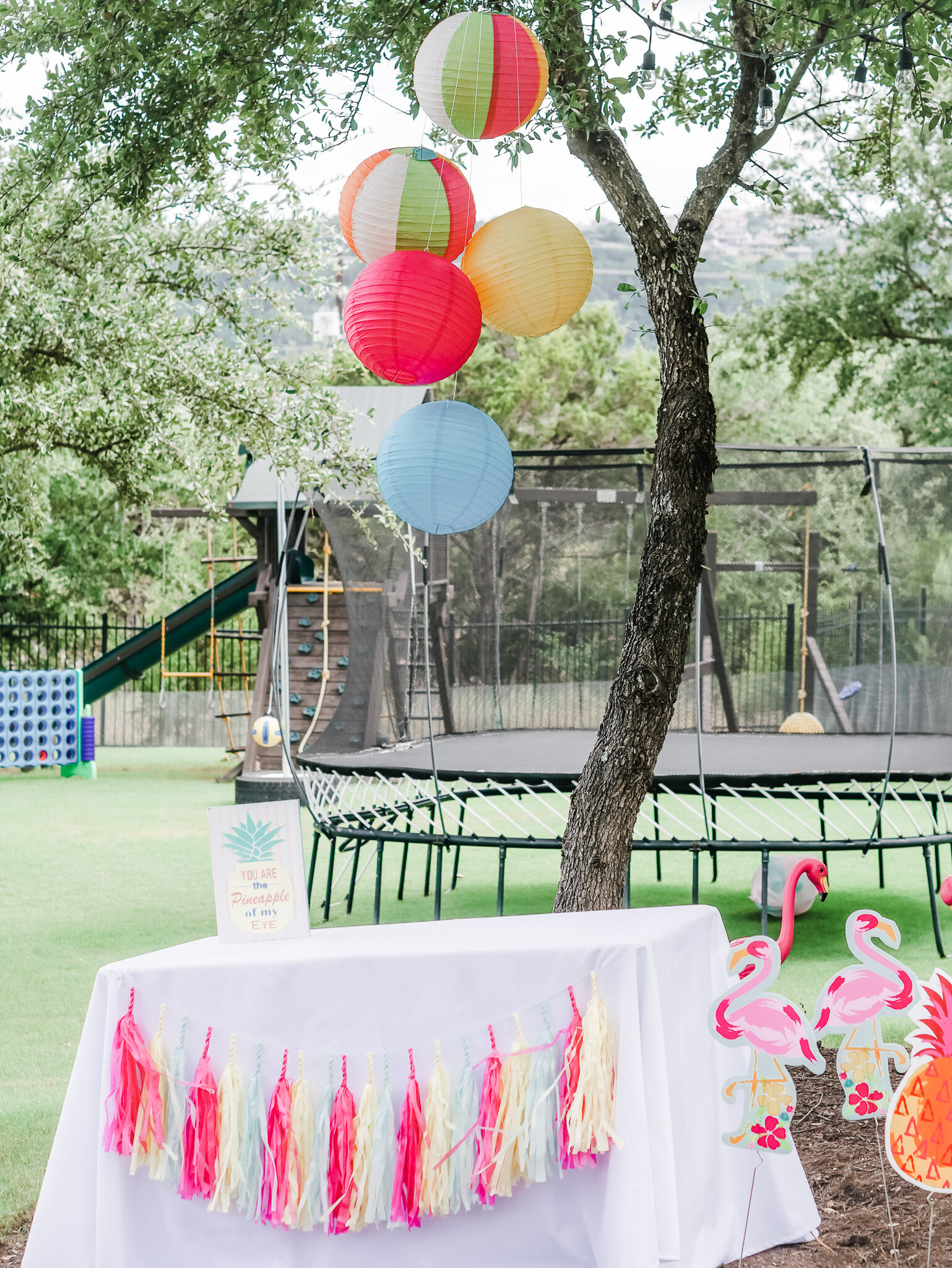  Welcome to the kids tropical birthday party. There’s tropical colored paper fringe garland and paper lanterns hanging to resemble beach balls. Come see all the tropical party details on Mint Event Design www.minteventdesign.com 