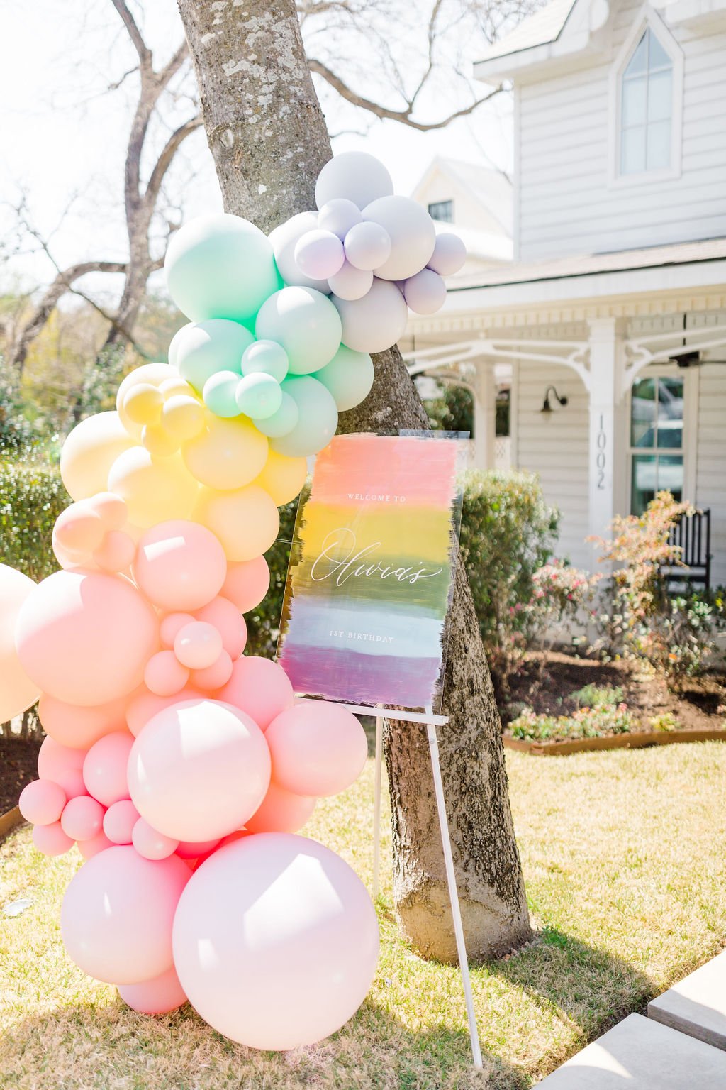 Rainbow Kid's Birthday Welcome Sign - a painted acrylic sign and a balloon garland. Details at www.minteventdesign.com!