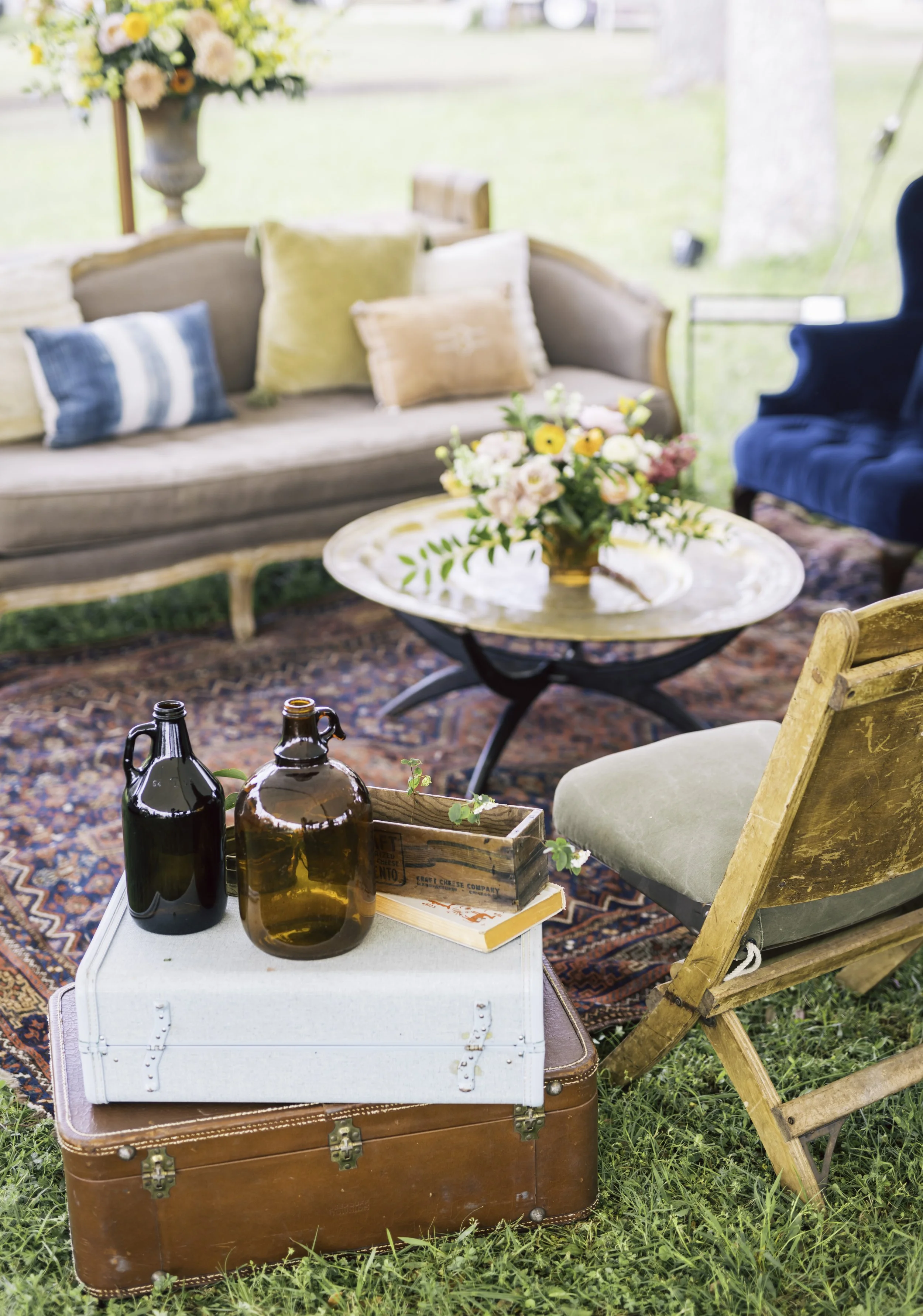 Vintage lounge with layered rugs, florals and decorative bottles styled by Austin event planner Mint Events