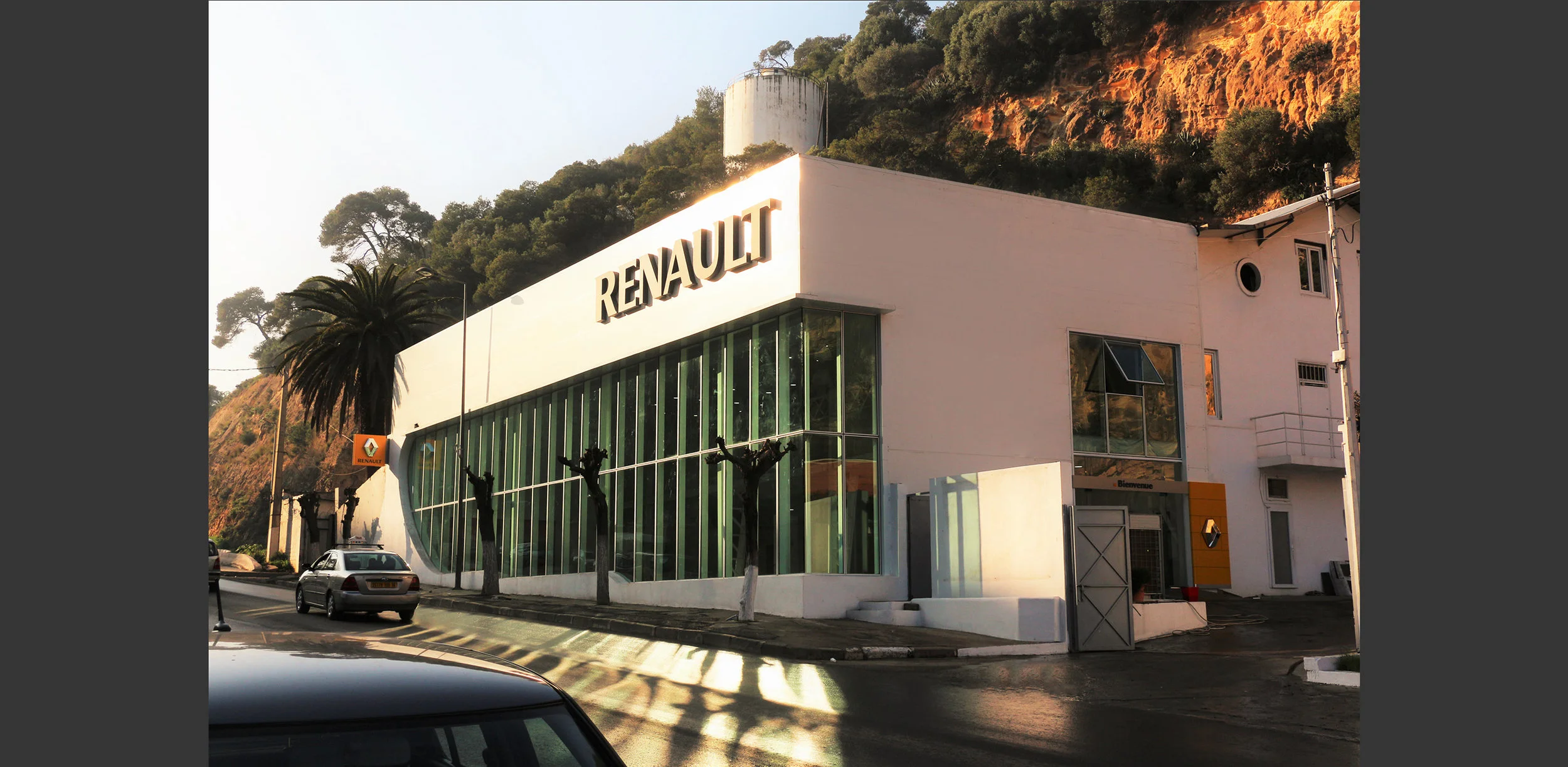 Showroom Automobile Alger - Algérie.Le bâtiment existant en charpente métallique ancienne assemblée par rivetage, présente une grande qualité spatiale. Notre intervention a permis de mettre en valeur ses qualités par le dessin d'une nouvelle structu…