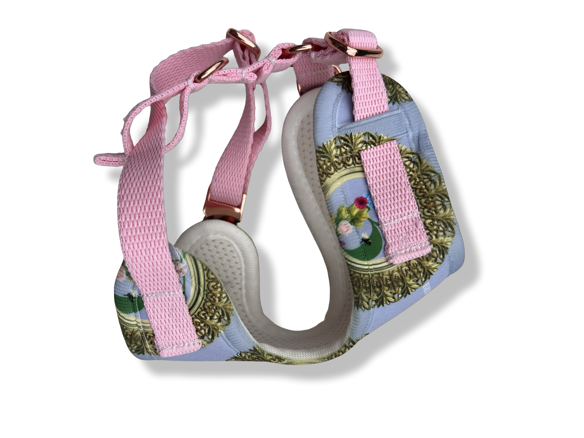 Decorative pink harness with straps and gold hardware, designed for a small dog or pet.