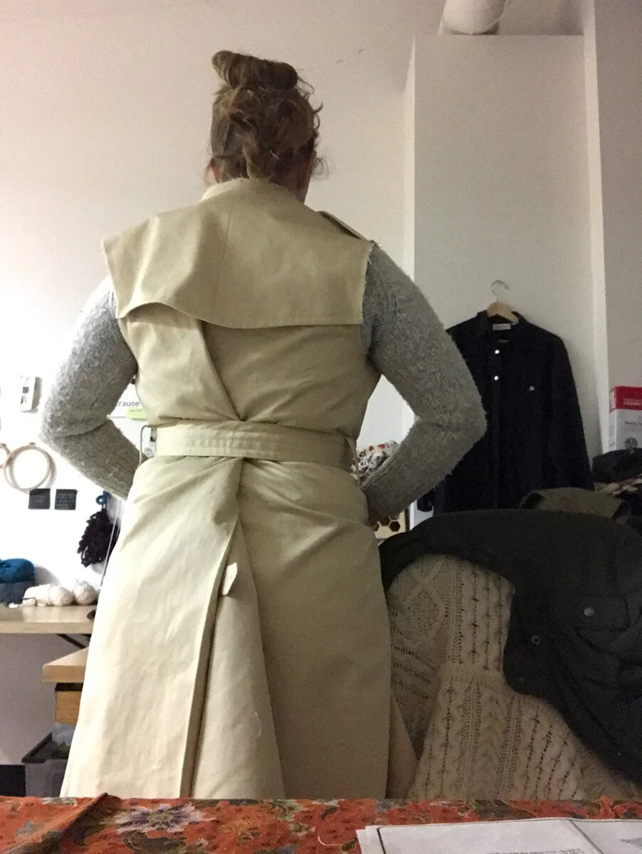 Seeing the garment come together as a recognizable item is always the most exciting part of these projects. Here, I had just sewed the entire body together, including the rain guard at the shoulders and extra kick lining with a button flap closure. …