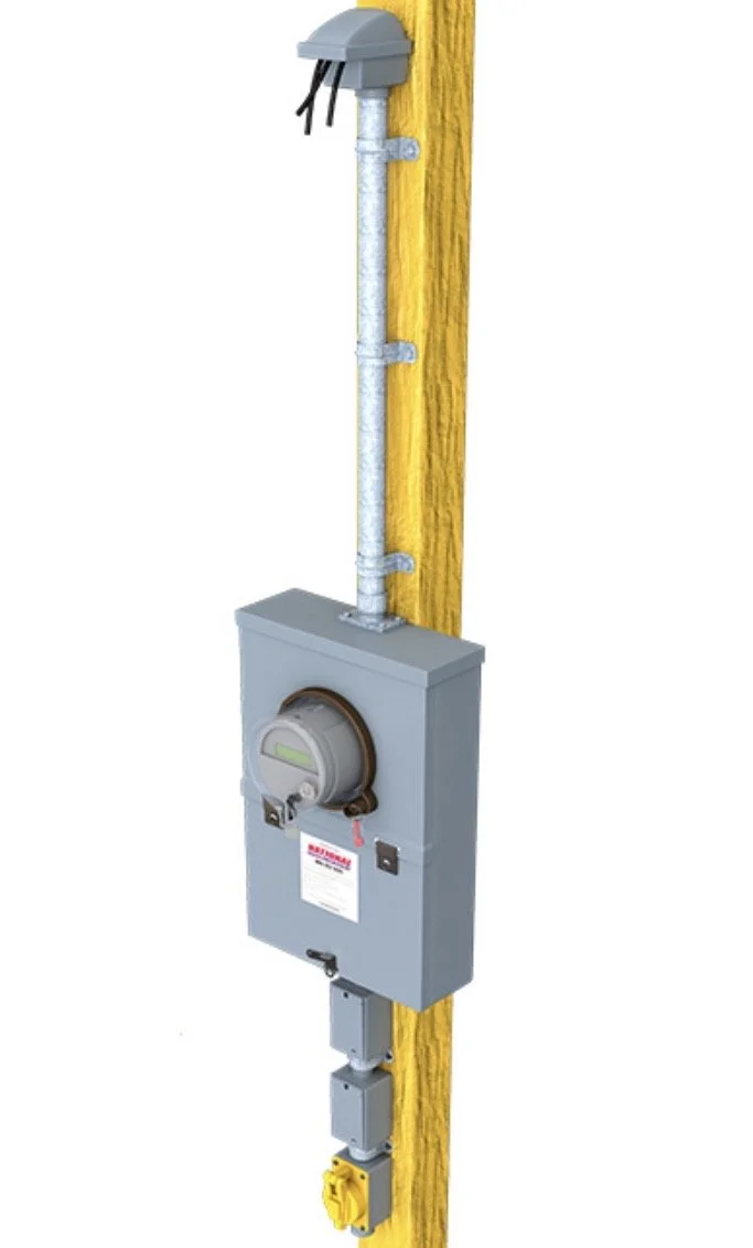 An electrical meter box installed on a yellow wooden wall with electrical wiring and connectors.