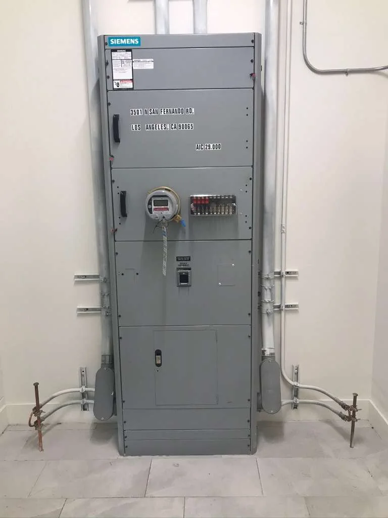 Electrical panel cabinet with Siemens branding, containing a digital meter, wiring, and labeled with address in Los Angeles, California.