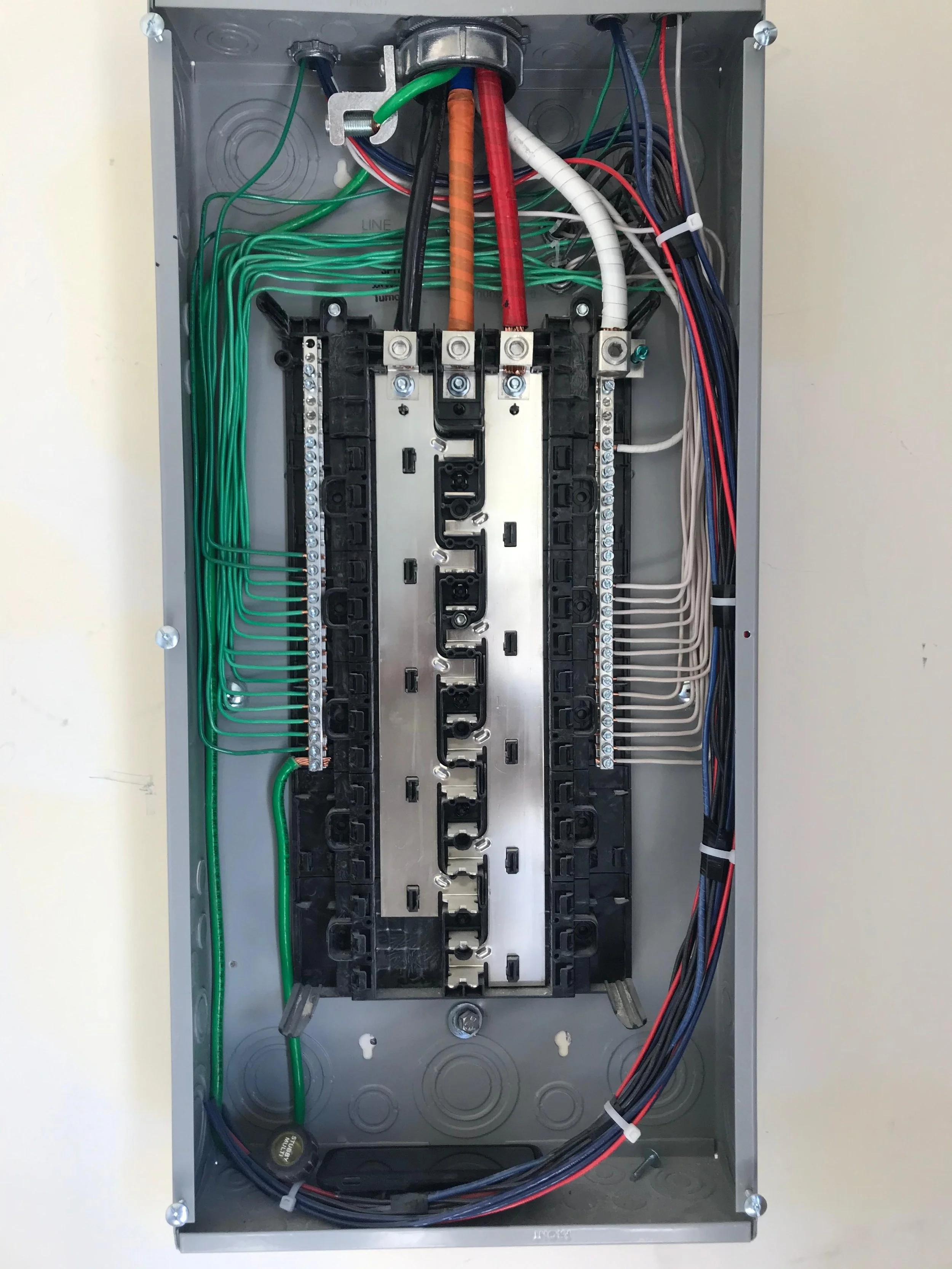 Inside an electrical control box with colorful wires, terminal blocks, and a circuit breaker.