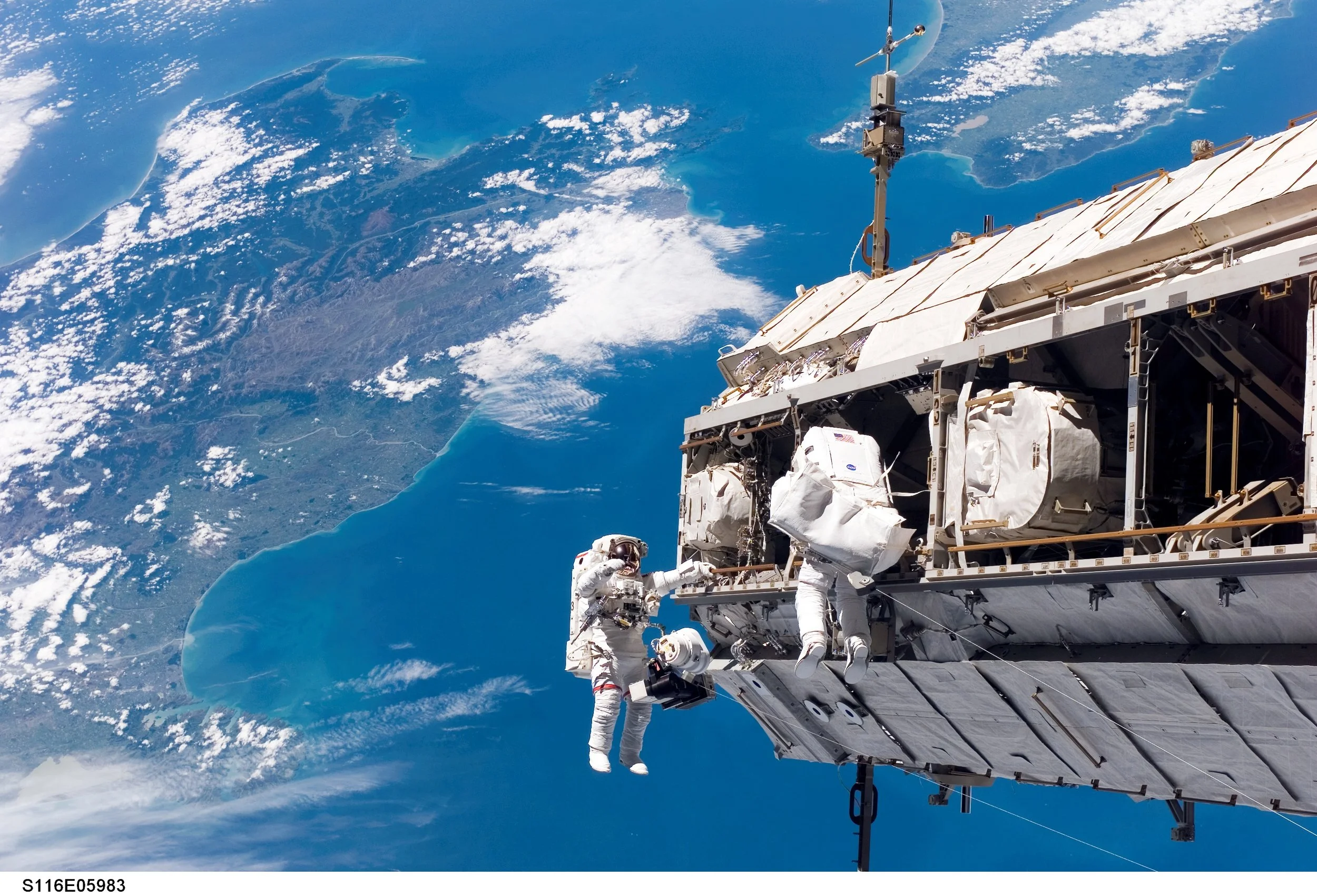 Curbeam (left) installing the International Space Station’s P5 truss over New Zealand during STS-116. (Photo: NASA)