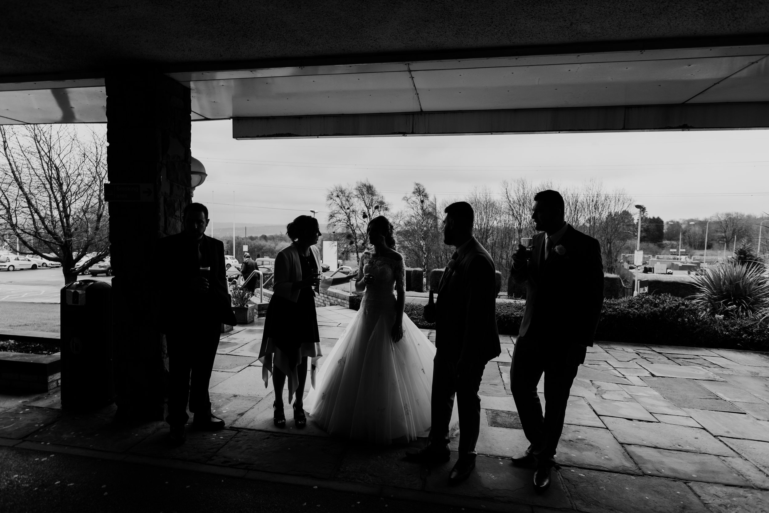 black and white image of bride and her wedding guests after the ceremony