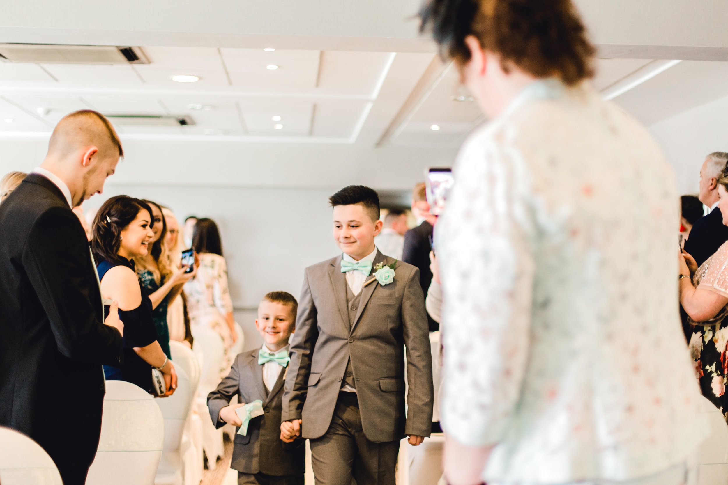 Pageboys walking down the isle before wedding ceremony at cedar court hotel, huddersfield