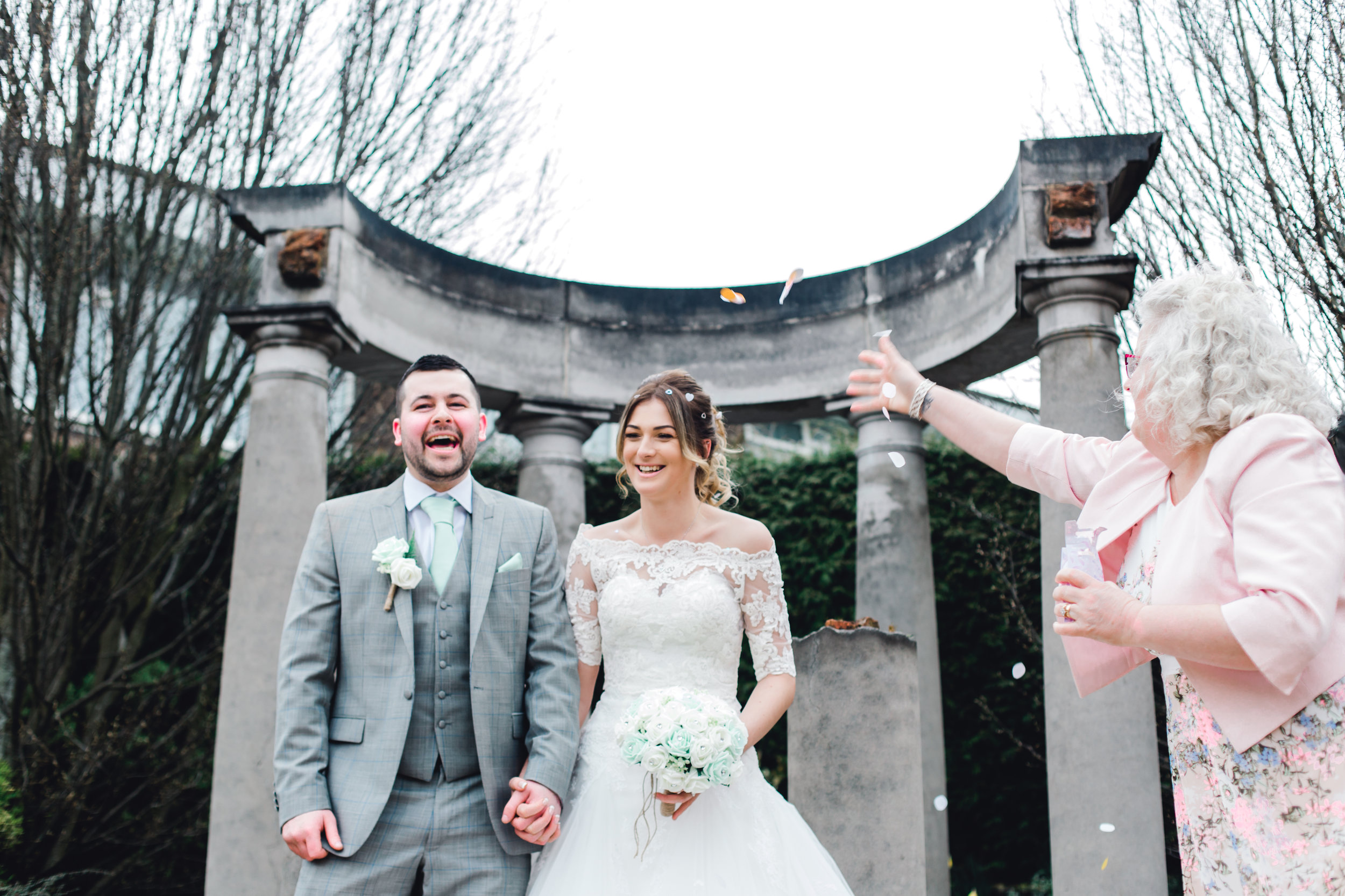 Funny confetti toss over the bride and groom