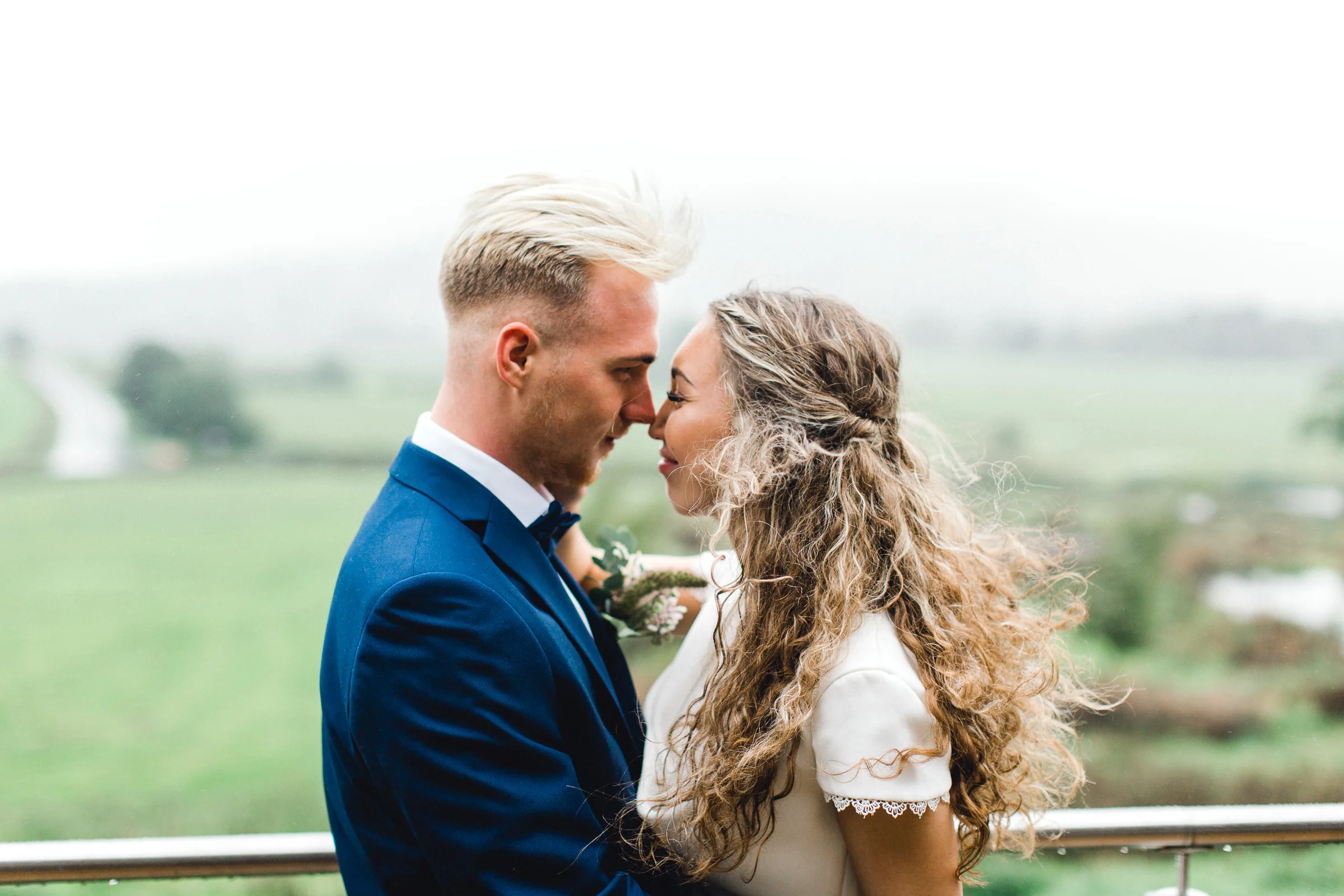 Bride and groom couples portrait on the terrace of bashall barn wedding venue in the rain and fog