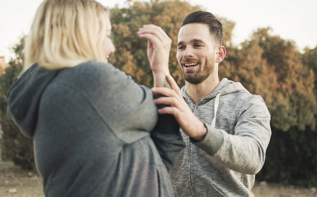 Man and woman working out together in park