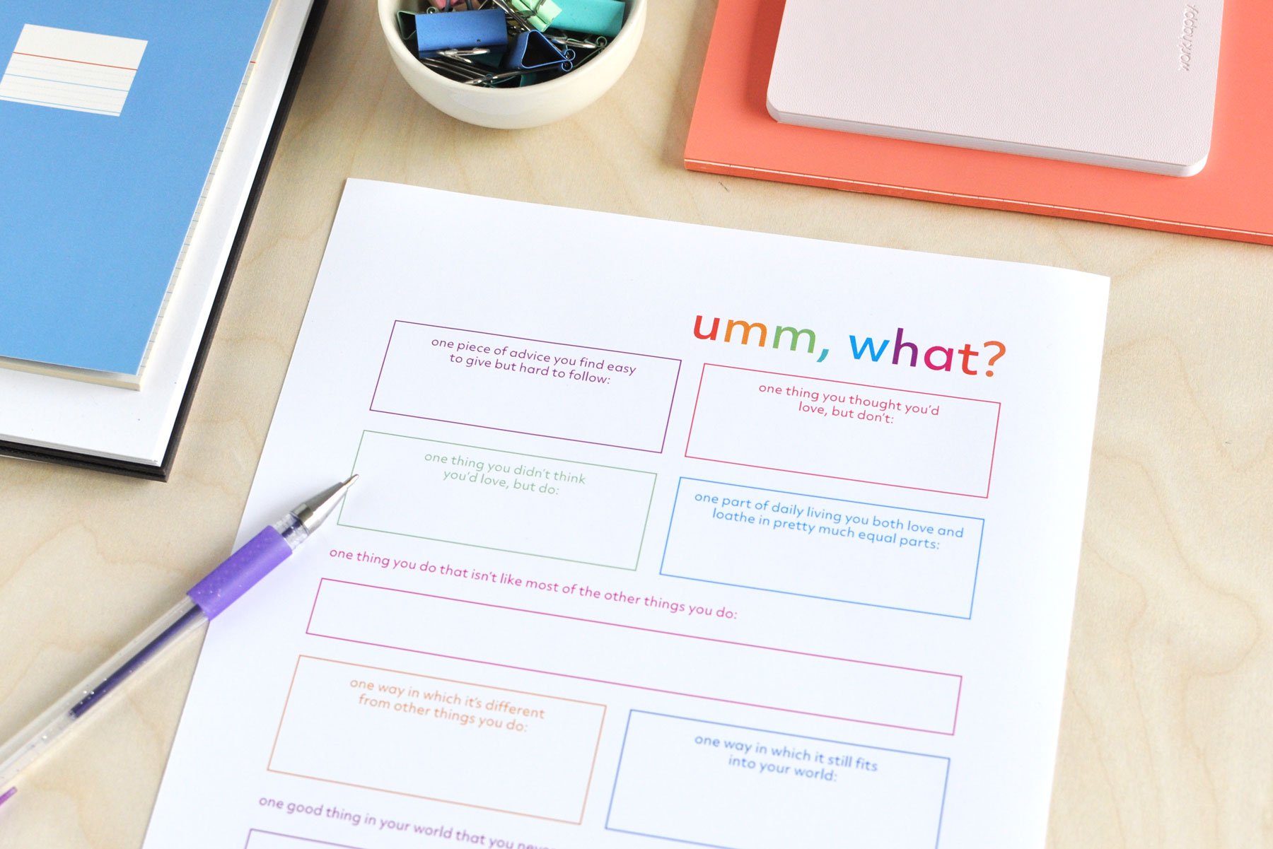 A colourful journal page titled Umm, What filled with writing prompts for reflecting on unexpected things. Shown with a purple pen and colourful notebooks.