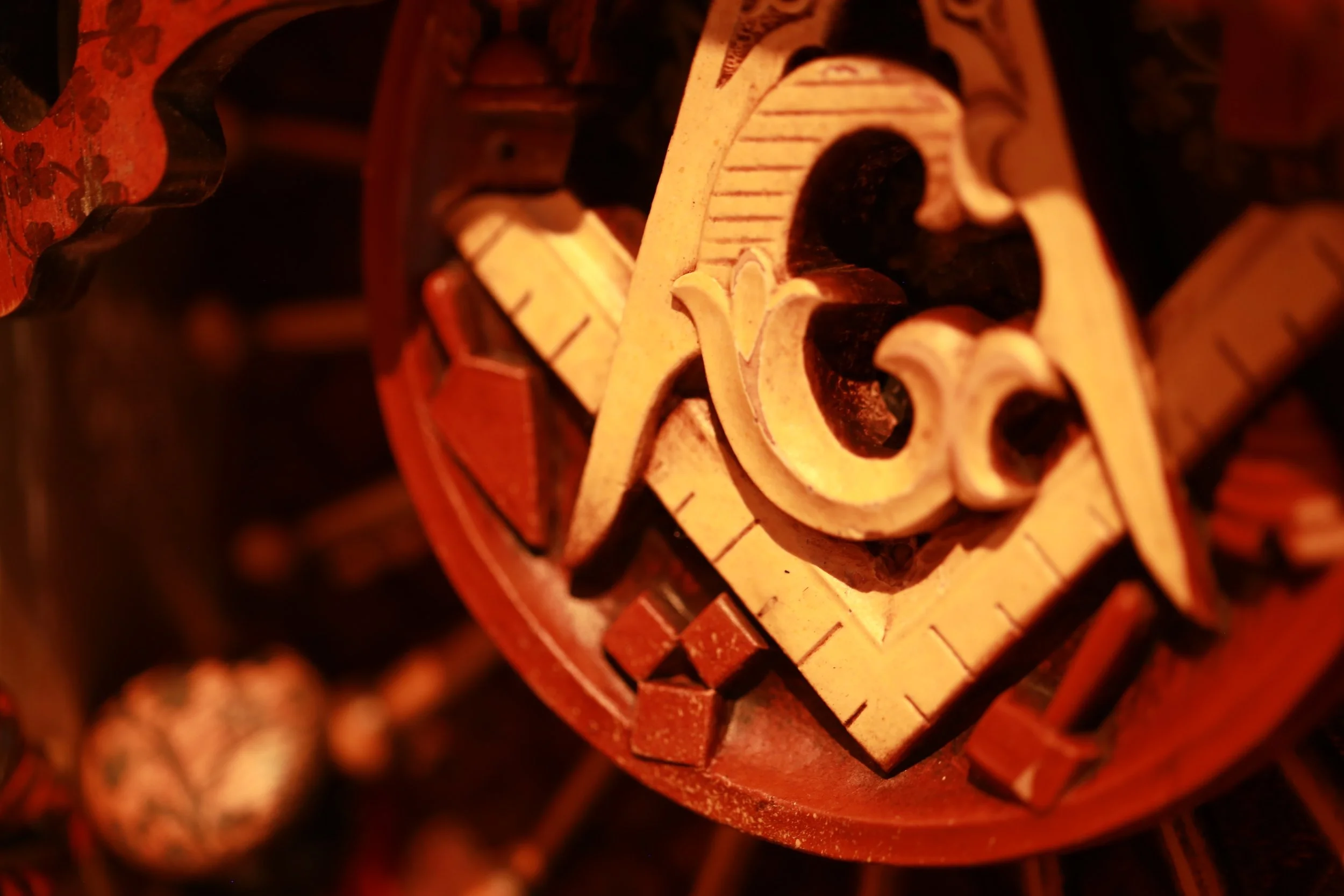 Close-up view of decorative carved and painted woodwork with intricate details and warm tones.
