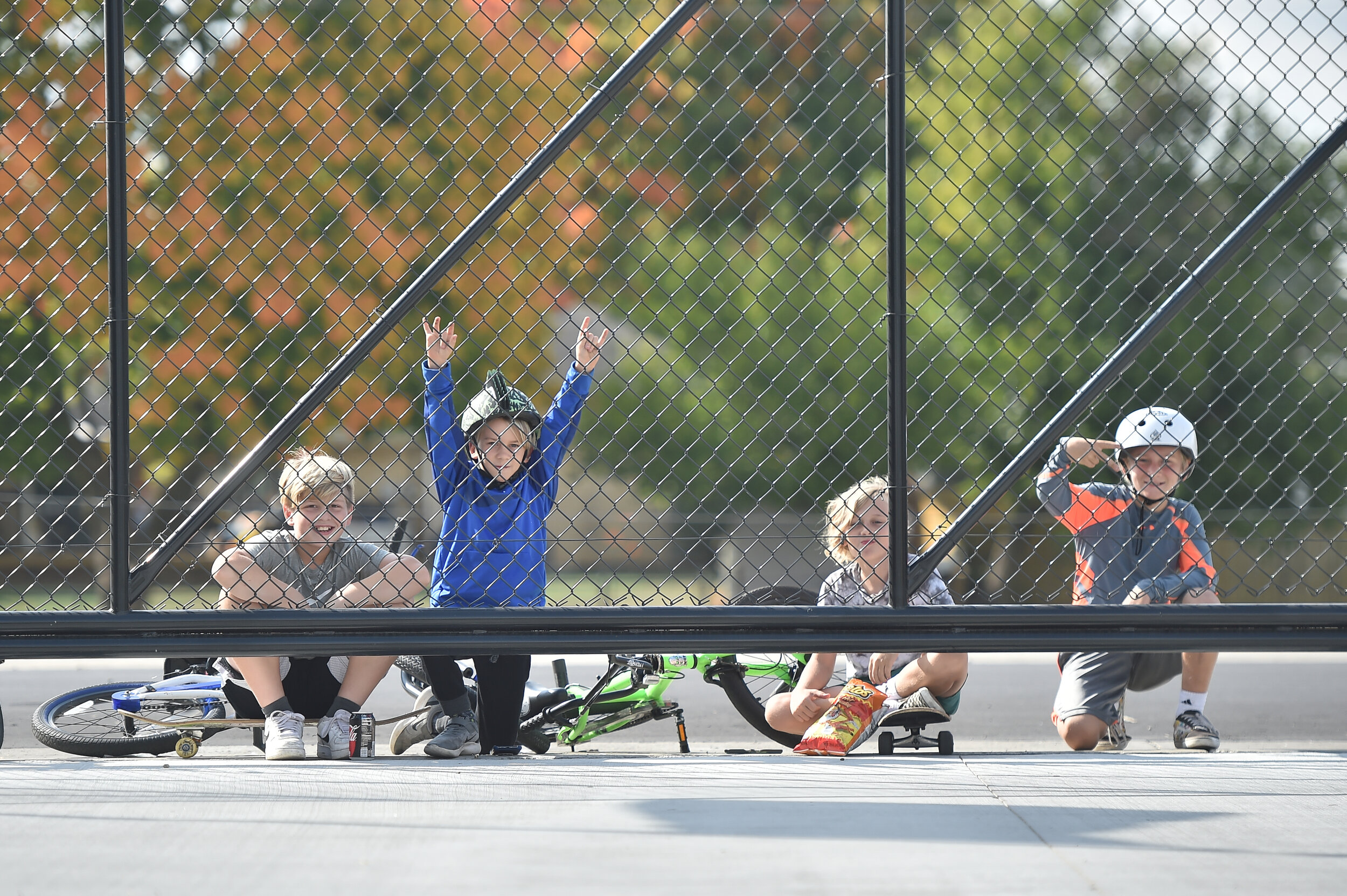  Neighborhood children watch the Harvest GP through a break in the fence.  