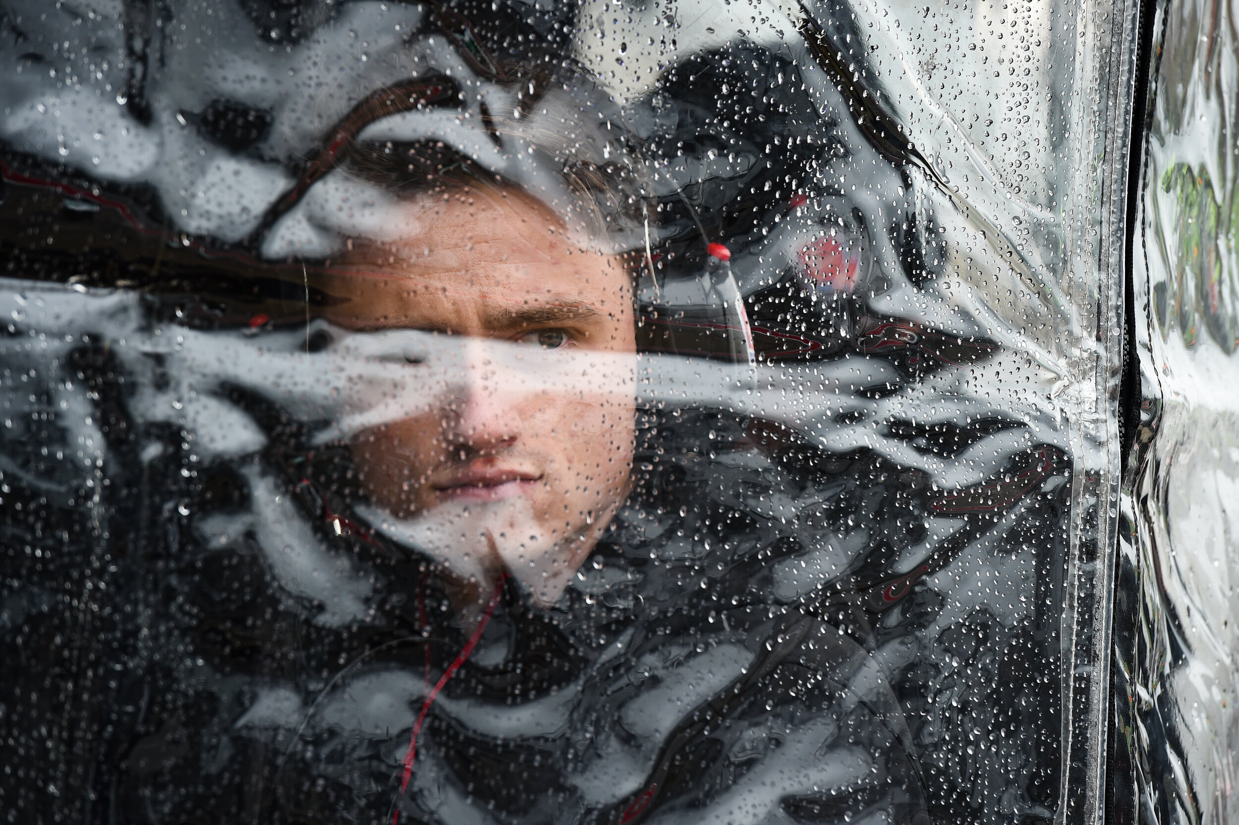  George Michael Steinbrenner watches the Andretti Autosport work during a wet spring training at COTA. The beads of rain and plastic make for a unique view for a photograph. One of my favorite portraits of the year! 