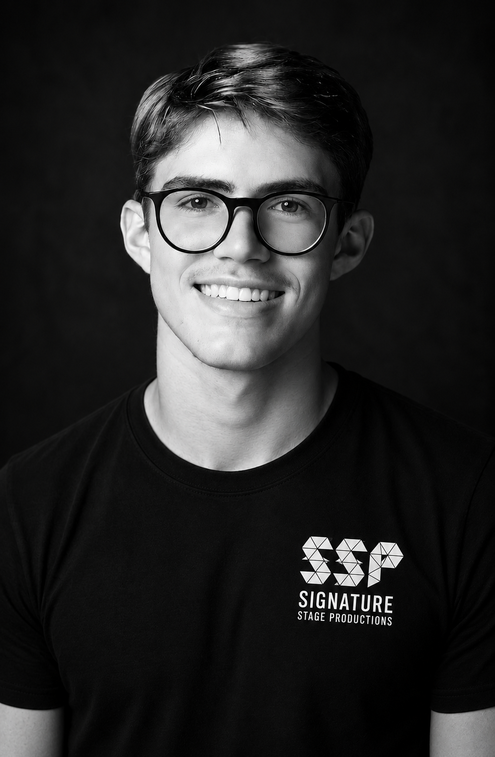Young man with glasses smiling in a portrait