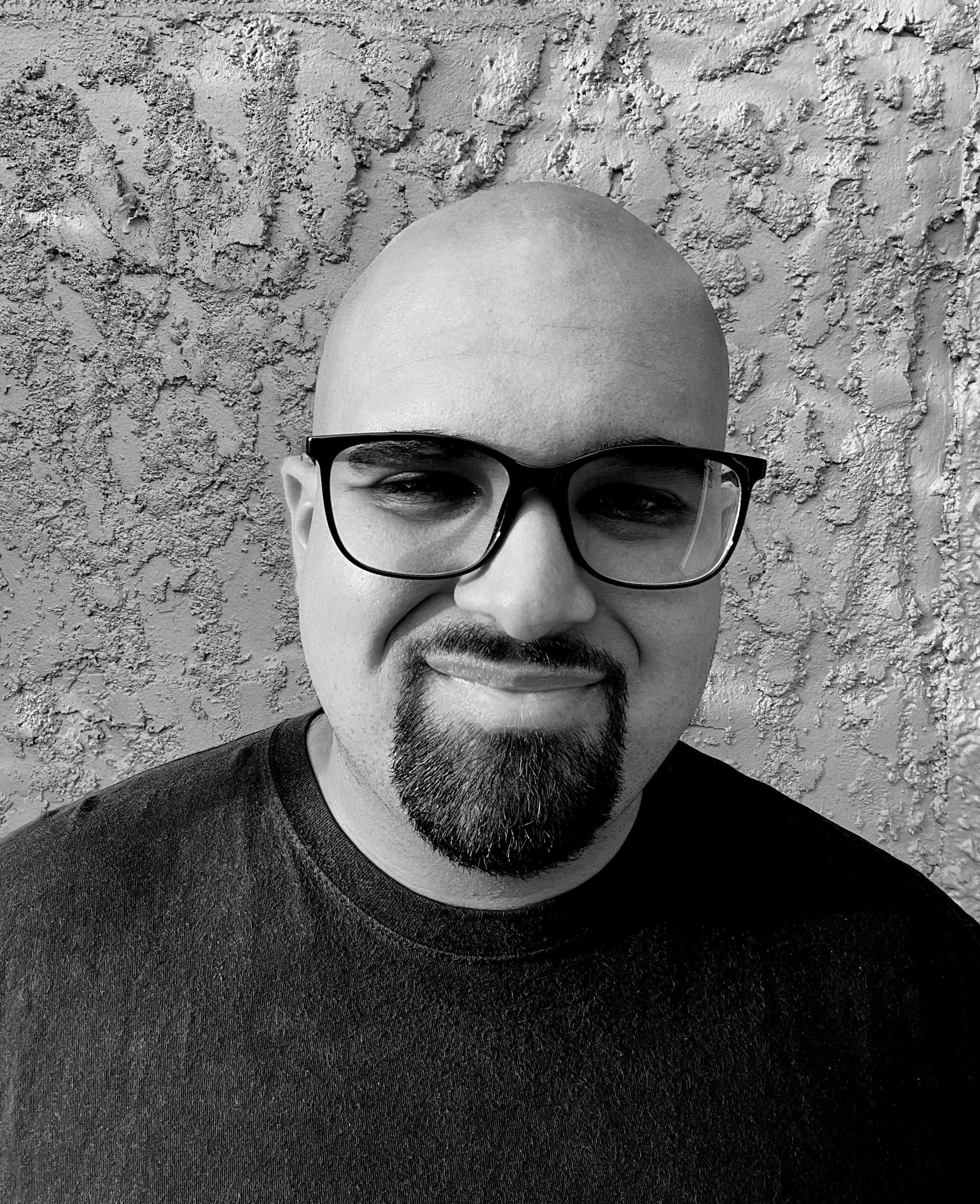 Alex with glasses smiling with black shirt