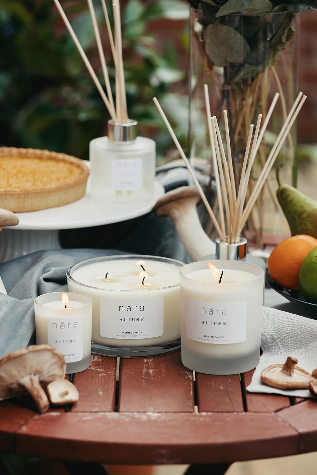 Full Autumn Scent range set outside with seasonal fruits, vegetables, pumpkin pie and plants.