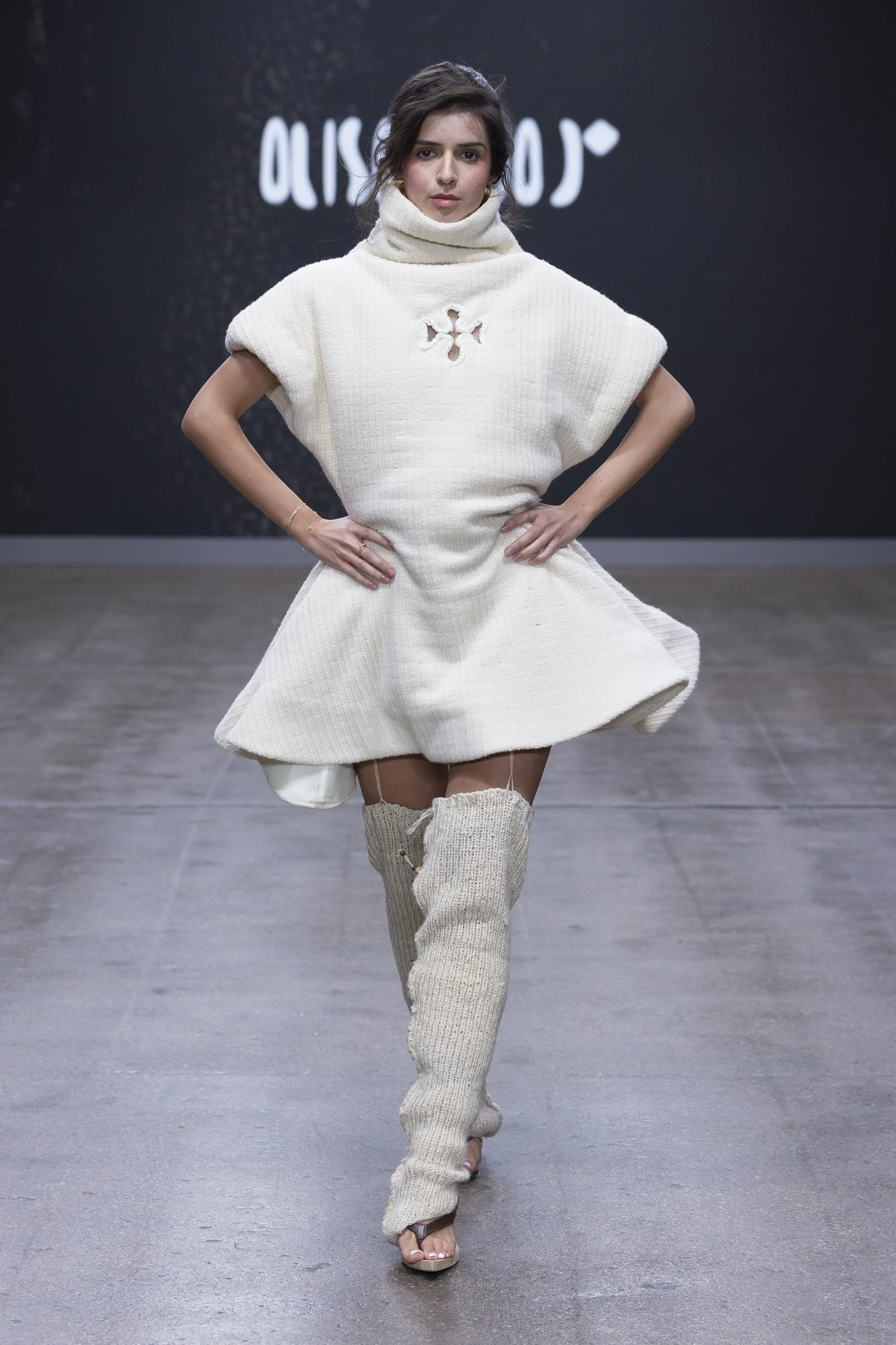 Model in a sculptural ivory wool mini dress and knitted legwear from ALISADUDAJ Silent Engravings at London Fashion Week SS26.