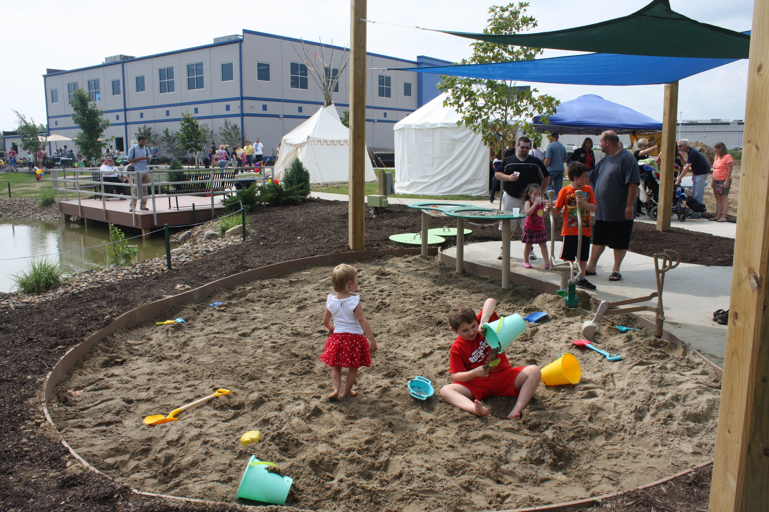 Sandpit with tent village and fishing dock in background