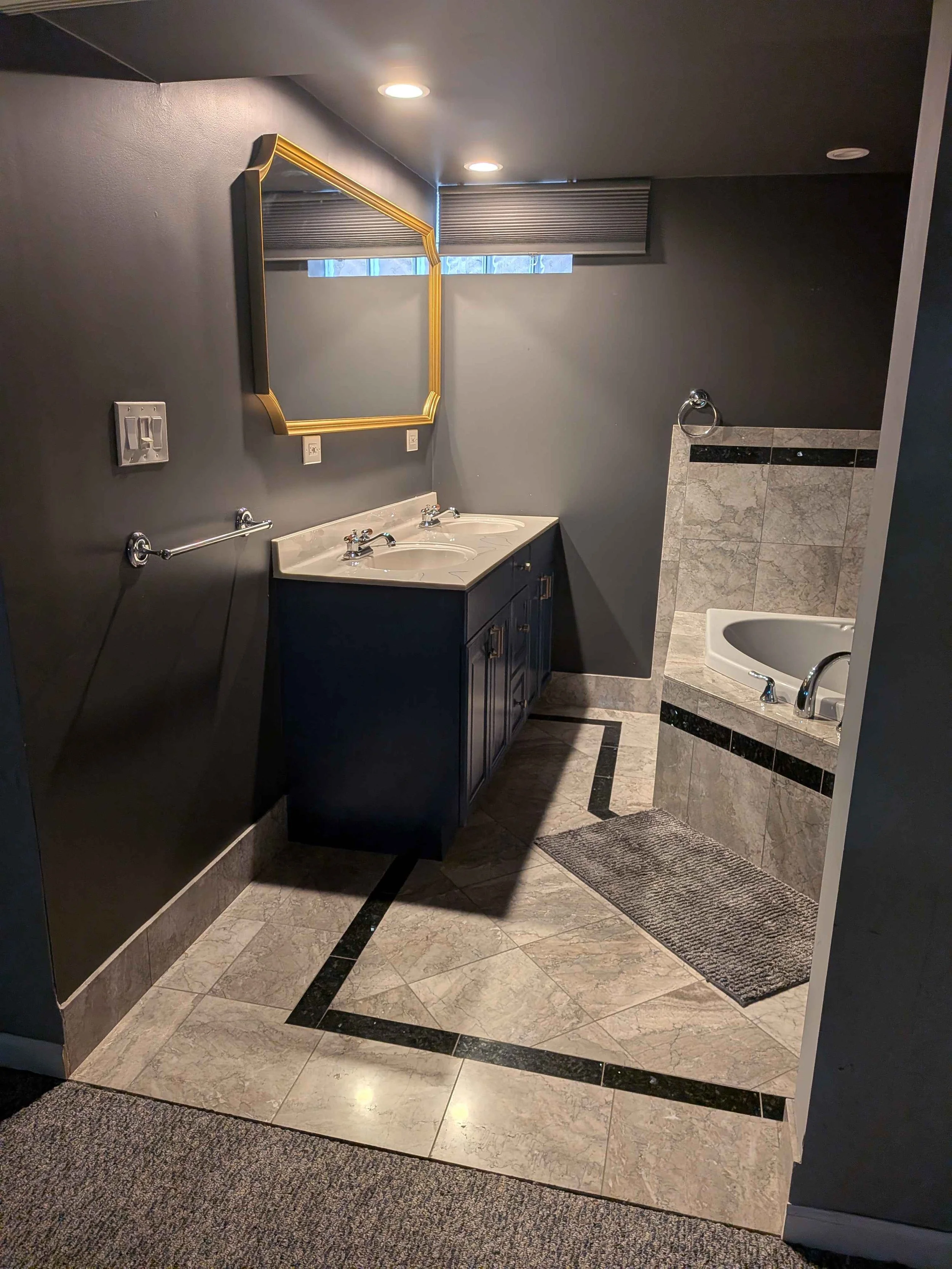 Interior view of a double sink vanity, a mirror, and some of a jacuzzi.