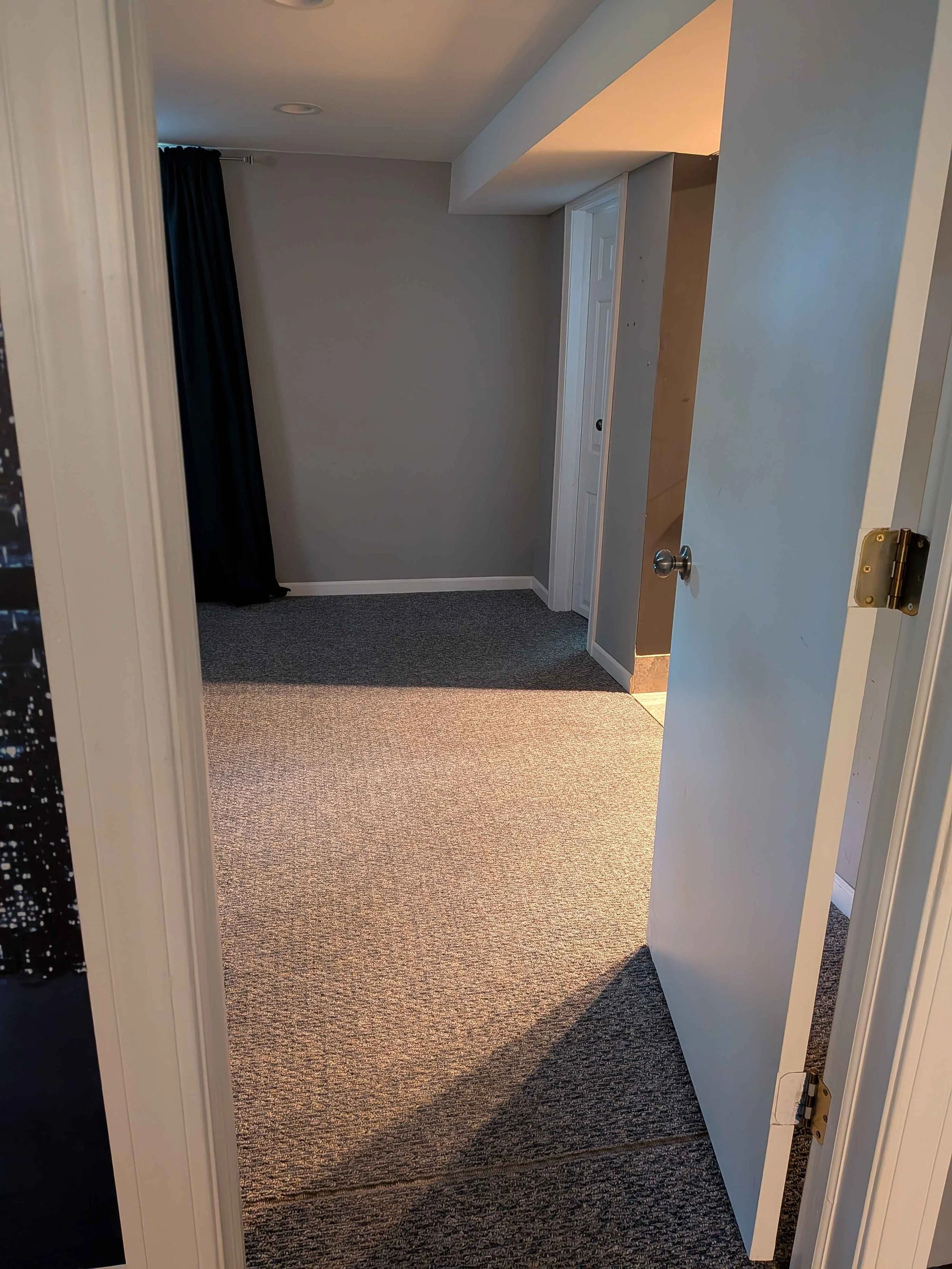 Doorway view of a bedroom, with a doorway inside the bedroom with light coming out.
