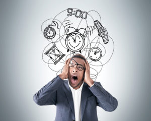 A man frustrated with images of clocks and watches over his head.