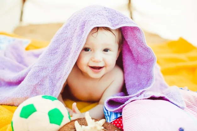 toddler-boy-lying-covered-with-purple-towel_1304-4148.jpg