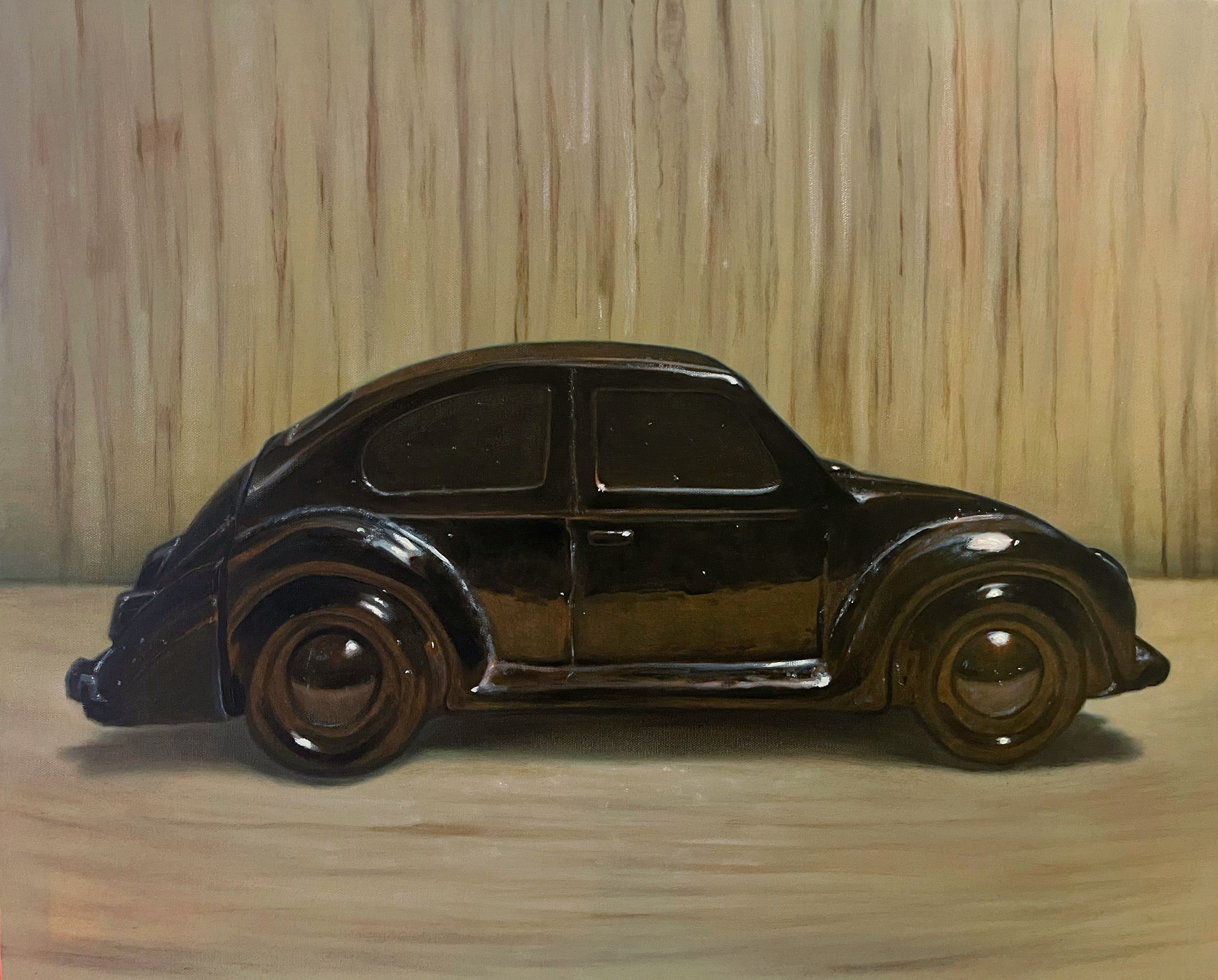 A painting of a black glass Volkswagen Beetle, l placed on a light wooden surface against a wooden background.