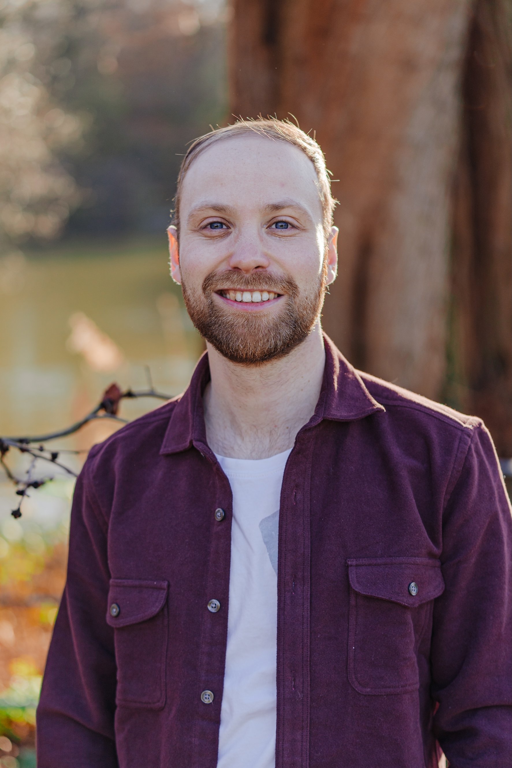 Image of therapist Daniel Eisenberg, an adult man with blue eyes and strawberry blonde hair in front of a tree outdoors