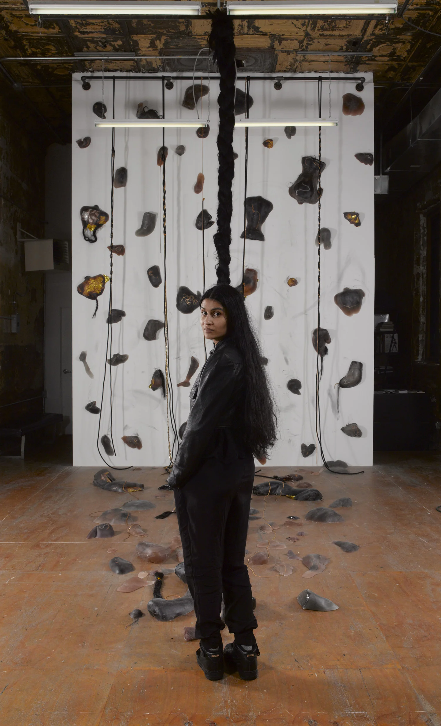 99 Holds , Indoor rock-climbing wall made from 99 unique poured dyed resin casts of the corners of the artist's body. Embedded with wearable Cuban chains, hair, and hypothermia blankets, 120 × 297 in, 2017