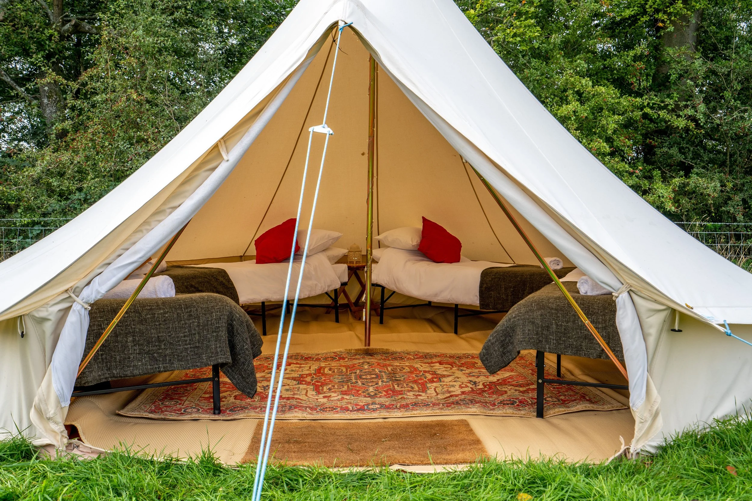 luxury bell tent with bedding and scatter cusions
