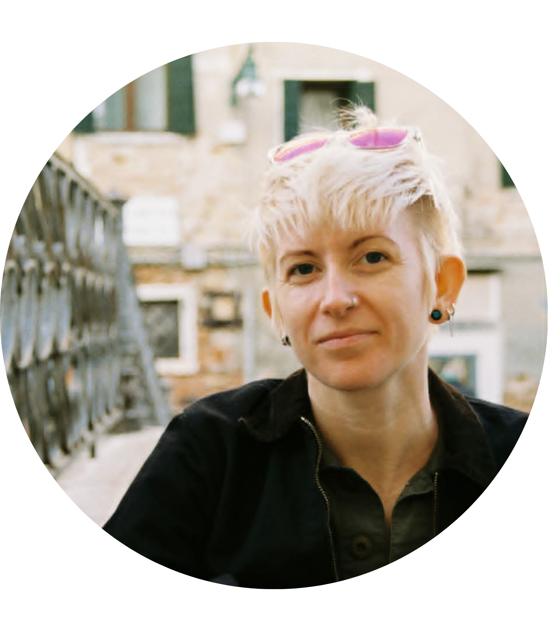 Ally Yancey sitting on a bridge, smiling softly at the camera