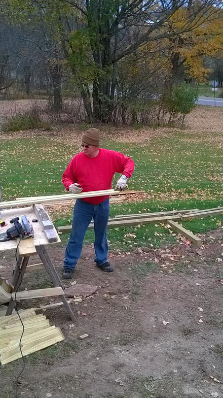 sawing_planks_red_sweatshirt_church_renovations_web.jpg