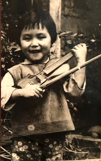 Jessica at 3 years old holding her first violin which her father made for her