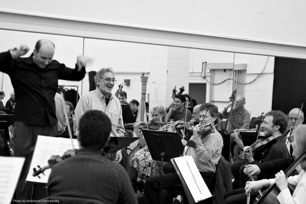 Domingo and conductor Emmanuel Villaume share a light moment with the orchestra . Photo Credit: Anastasia Chernyavsky