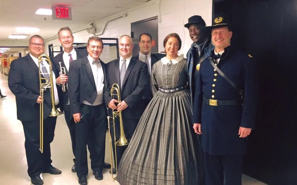 Members of the brass section with conductor Dante Santiago Anzolini and members of the cast of Appomattox