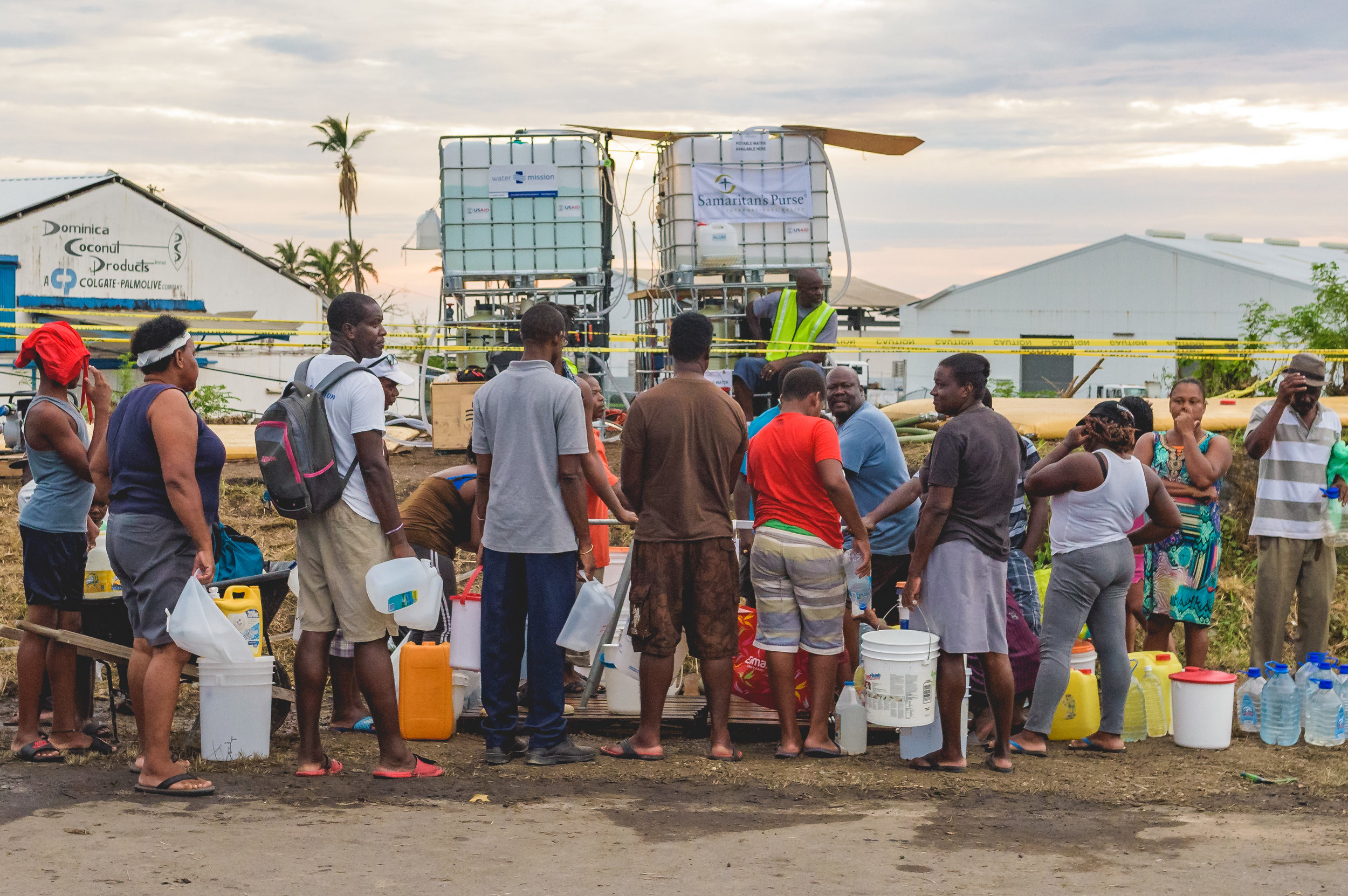 Roseau, Dominica - Residents line up at a water distribution station with anything that will carry water.