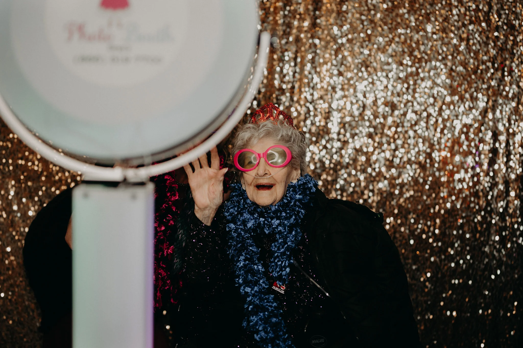 Grandmother wearing pink glasses in gold glitter Michigan photo booth