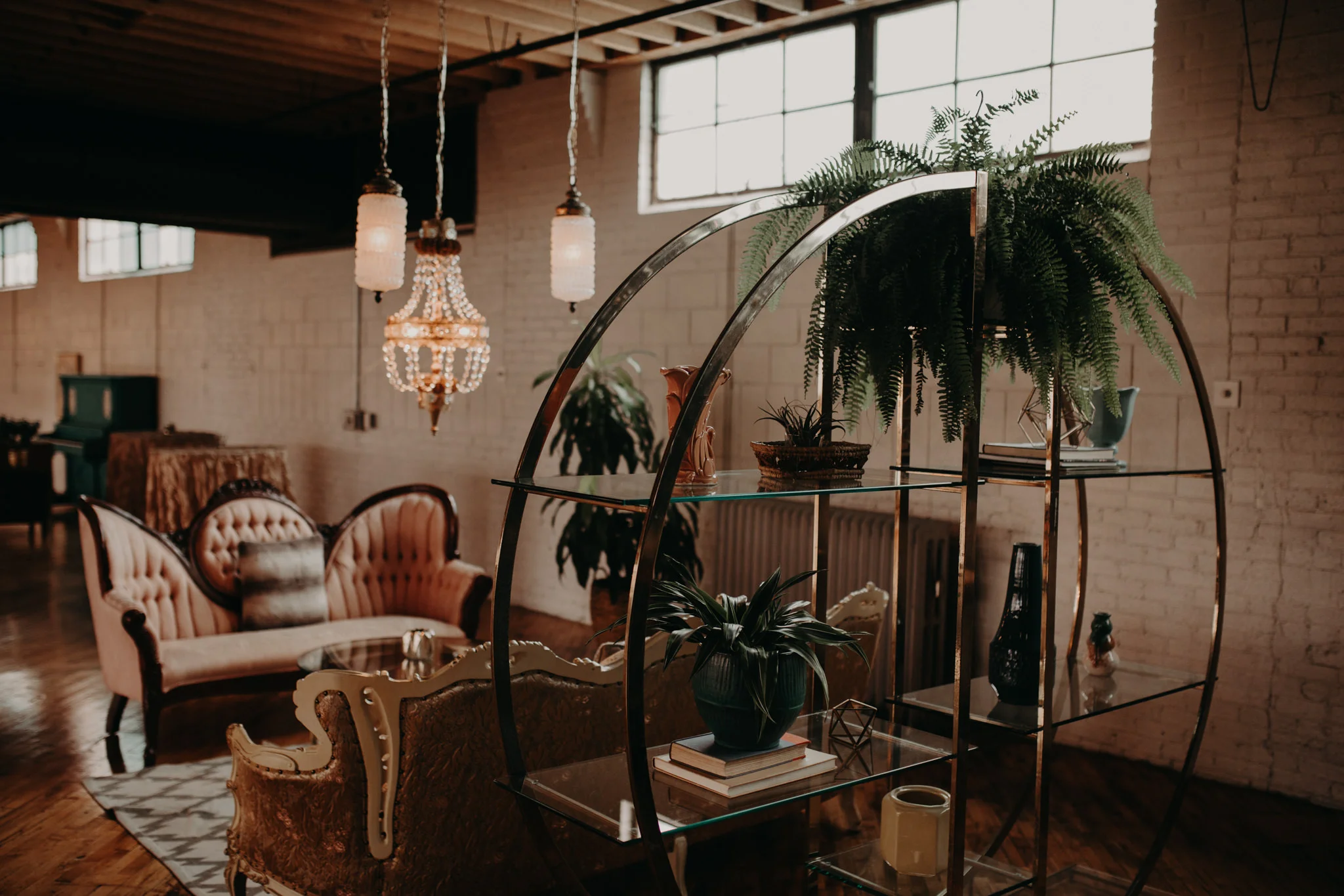 Greenery hanging over gold shelf in front of victorian couch
