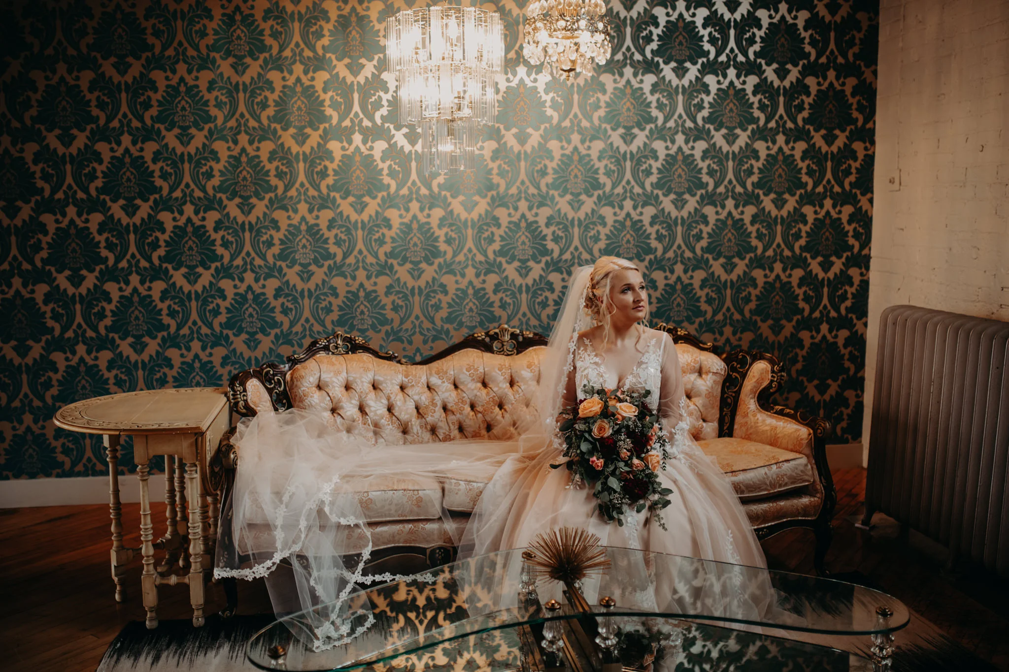 Bride sitting on blue couch in front of blue mural at The Cheney Place