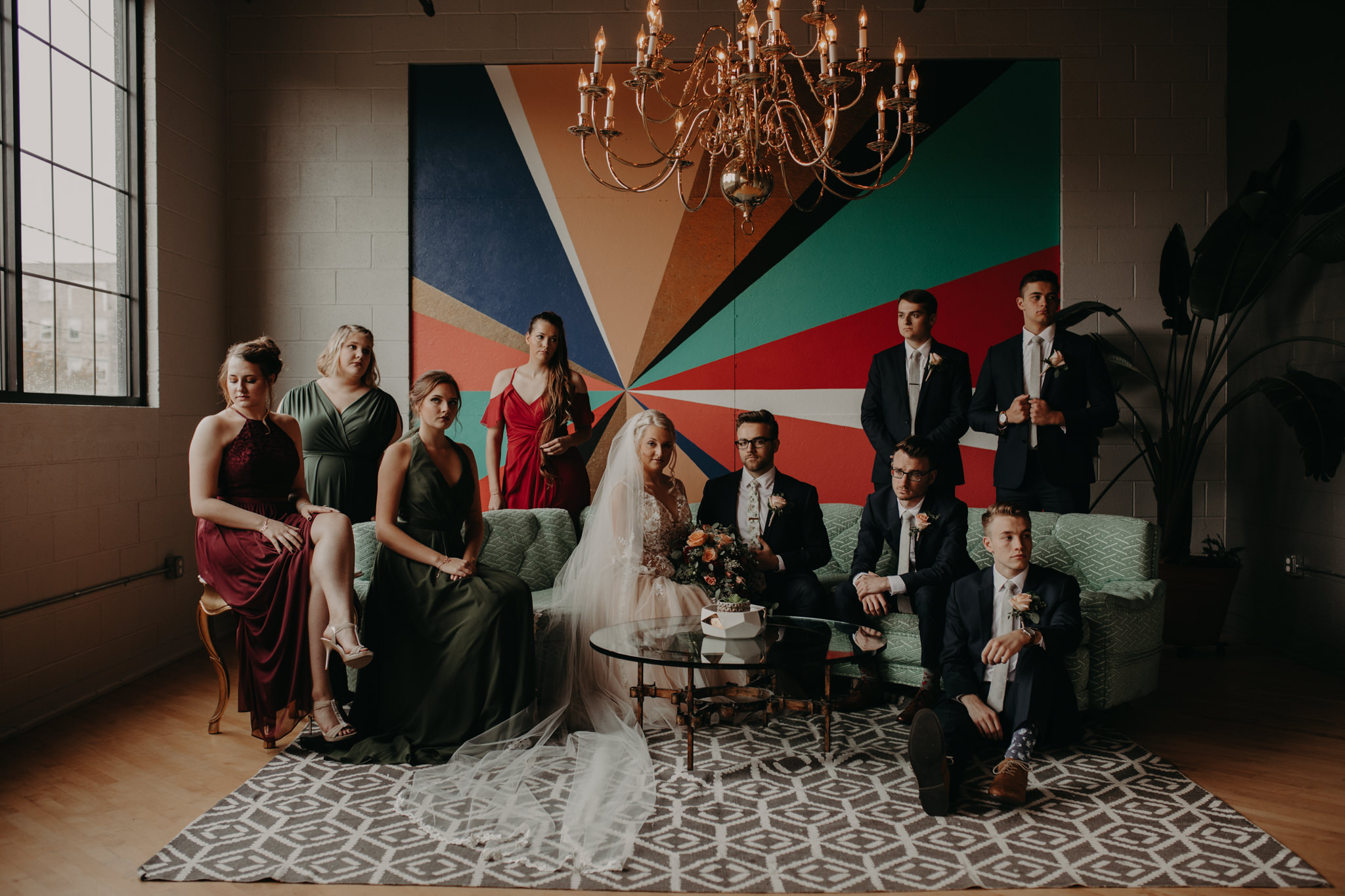 Bridal party sitting in front of rainbow mural at The Cheney Place