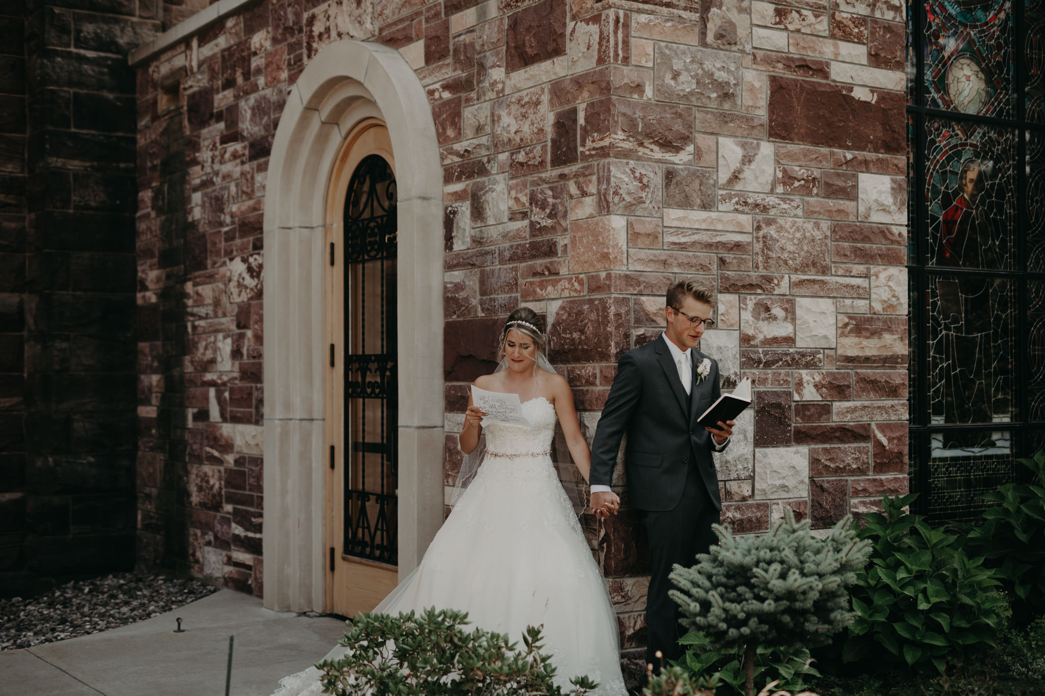 Bride and groom reading letters at St. Peter Cathedral in Marquette
